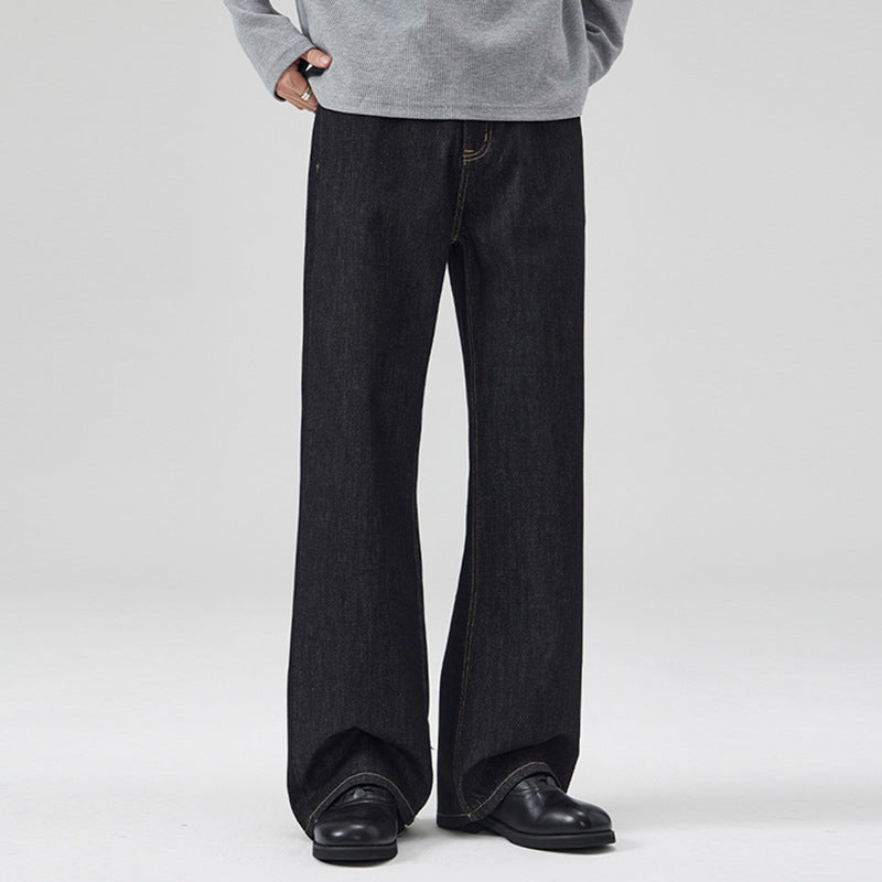 Person wearing black wide-leg jeans and a gray sweatshirt on a white background