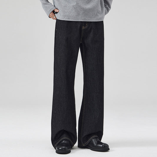 Person wearing black wide-leg jeans and a gray sweatshirt on a white background