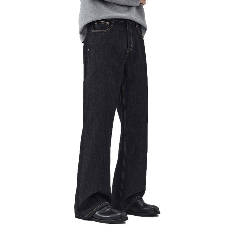 Person wearing black wide-leg jeans on a white background